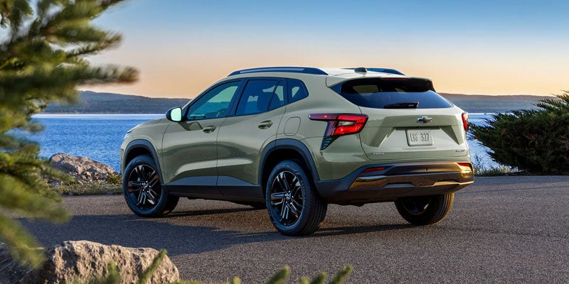 A light green 2026 Chevy Trax is parked near water at dusk
